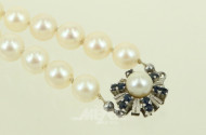 Lange Akoya-Perlenkette mit Schließe in 750 WG, besetzt mit kl. Saphiren und 1 Perle