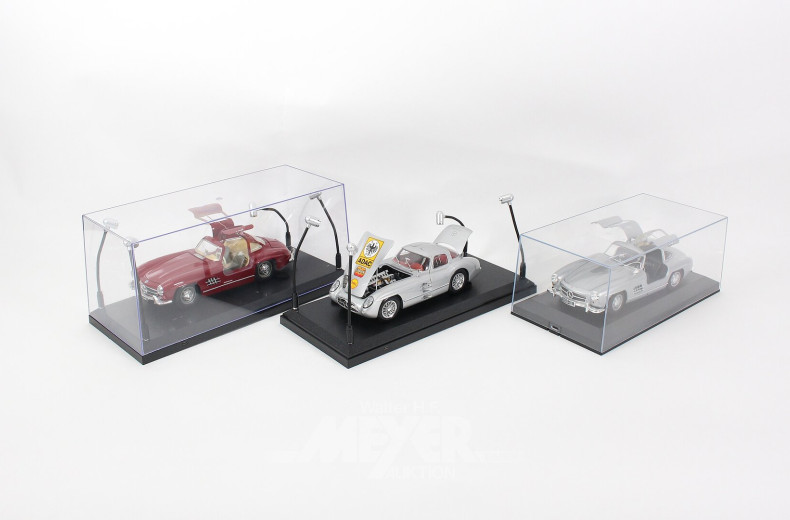 9 Modellautos im Schaukasten, tlw. beleuchtet, 1:18