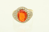 Ring mit einem orangen Farbstein (vermutl. Feueropal) oval facettiert, umgeben von kl. Brillanten