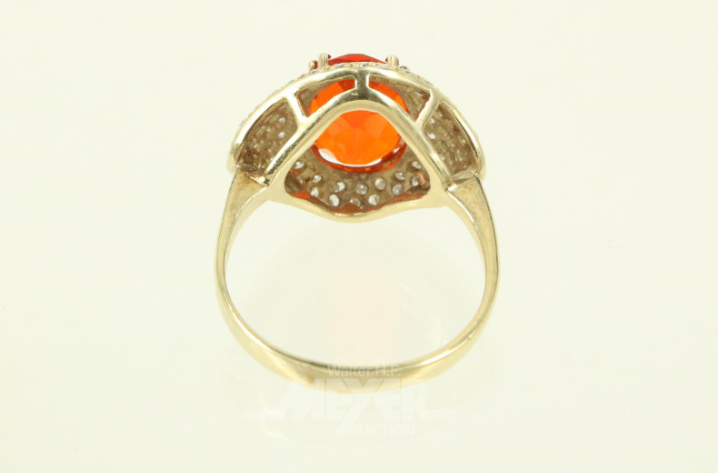 Ring mit einem orangen Farbstein (vermutl. Feueropal) oval facettiert, umgeben von kl. Brillanten