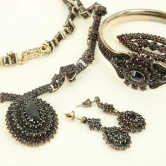 4-tlg. Schmuckset mit Granatbesatz in 900er Silber, best. aus Collier, Brosche, Armreif u. Paar Ohrhänger